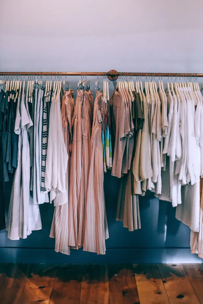 A rail of neutral-toned clothes in a boutique